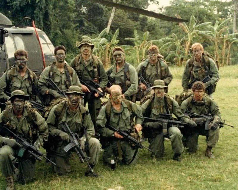 Delta Force Operators in Panama take a photo next to a Helicopter