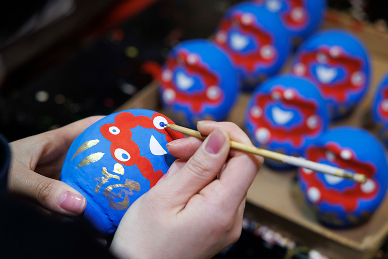 縁起の良い“願掛け”の文字が記された、色とりどりの「だるまの